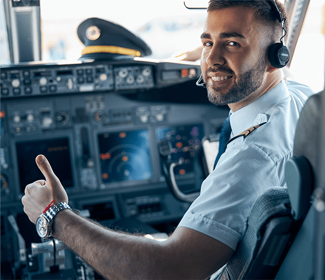 hispanic pilot in cockpit of plane smiling giving thumbs up